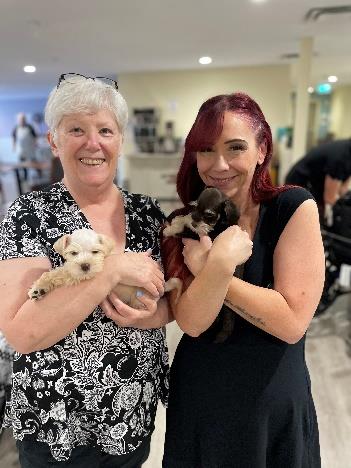 2 Women Holding Mini Schnauzer Puppies