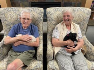 Senior Couple Holding Mini Schnauzer Puppies